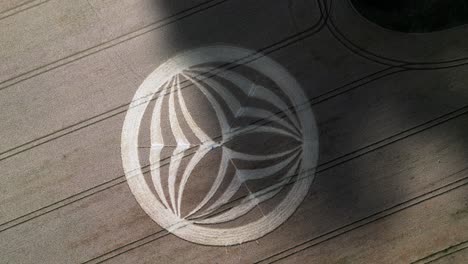 Aerial-view-looking-down-over-Warminster-symmetrical-crop-circle-partially-covered-by-cloud-shadow-on-rural-farmland-field