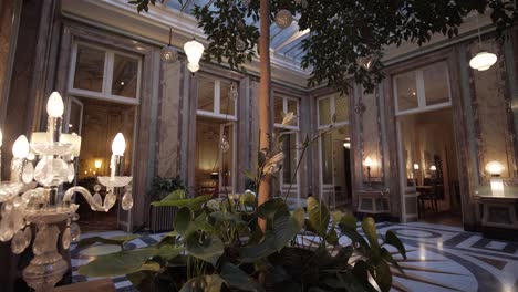 revealing shot of a conservatory with a table and chairs under the skylight within a french mansion