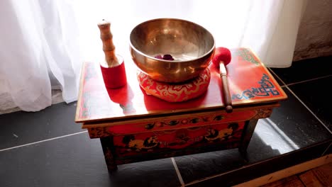 buddhist hotel with red and black wooden furniture, copper basin, and various spiritual tools