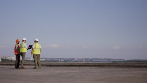 equipo de construcción discutiendo planes en el techo