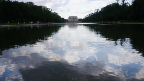 view from the water to the front steps of the lincoln memorial taken from the reflection pond with people in the foreground