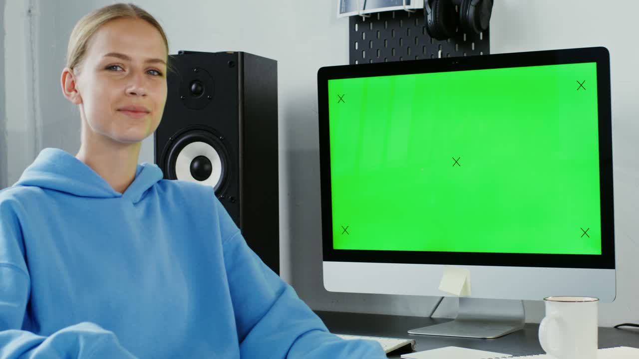 녹색 스크린을 가진 가정 스튜디오의 여성