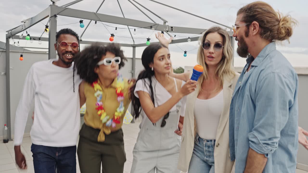 Group of friends enjoying a party on a rooftop, dancing and singing with a microphone