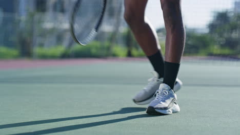 tennis player tying shoelaces on the court