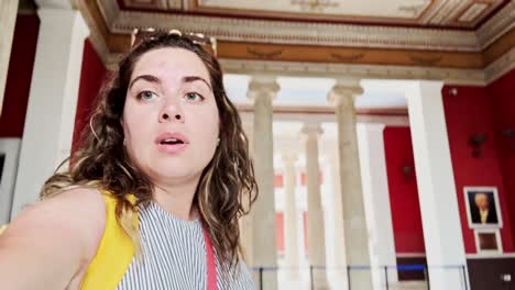 woman vlogging inside zappeion hall with columns background