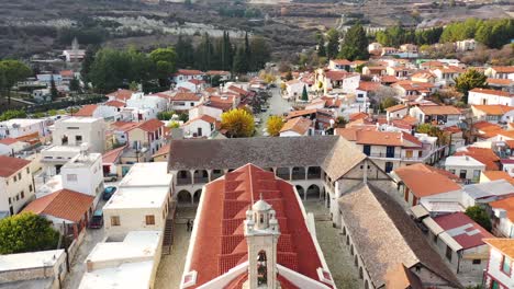 Drone-Volando-Bajo-Sobre-El-Monasterio-Cristiano-Hacia-La-Entrada-Principal-Del-Pueblo-De-Omodos,-Ciudad-De-Limassol,-Chipre