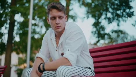 young man sitting on a park bench