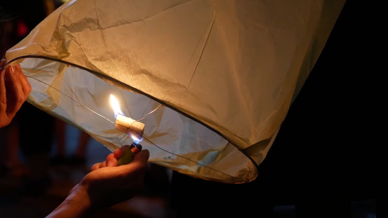 Lighting a Sky Lantern at Night