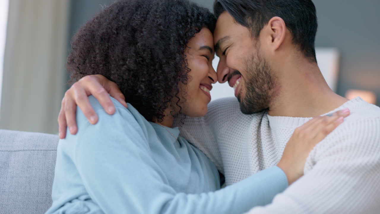Couple, hug and smile on sofa