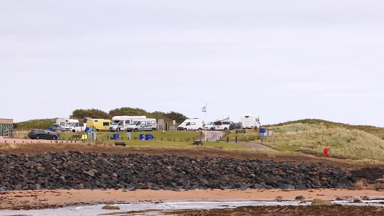 건물 과 풀 인 언덕 이 있는 해변 풍경
