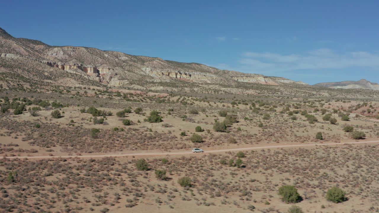 먼지 가득 한 원격 사막 도로 에서 자동차 를 운전 하는 것 을 따르는 공중 전망