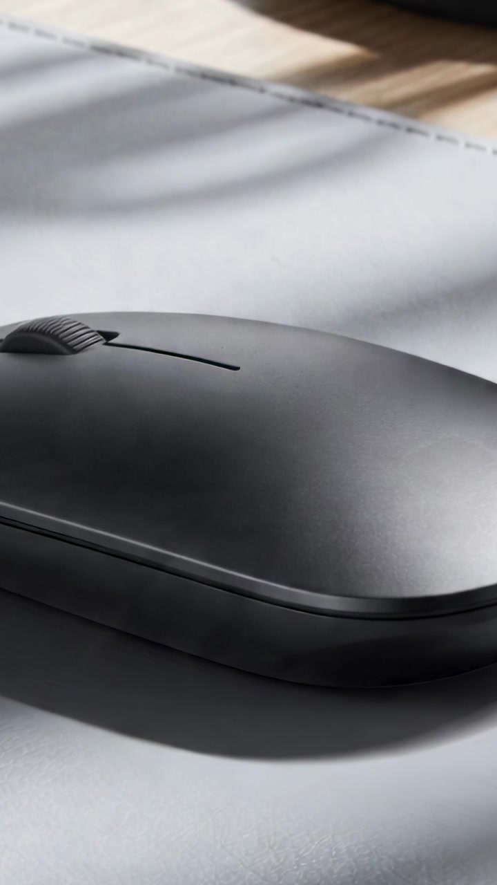 Vertical video: Sliding striped sunlight and camera pan revealing mouse on desk pad to reveal wheel