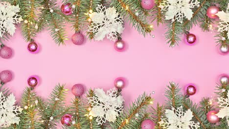 hermoso arreglo navideño pastel en ramas de pino con adornos y luces parpadeantes en tema rosa pastel.
