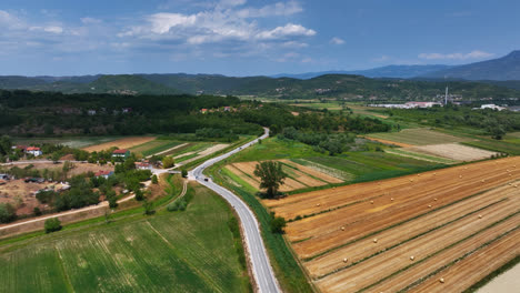 Drone-rising-over-traffic-on-a-road-and-vivid-fields,-warm,-summer-day-in-Istria,-Croatia