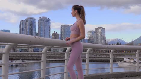 model woman posed in athletic clothes with vancouver bc city skyline, wide shot