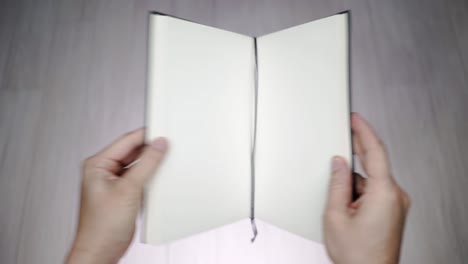 blank textbook opening with hands.