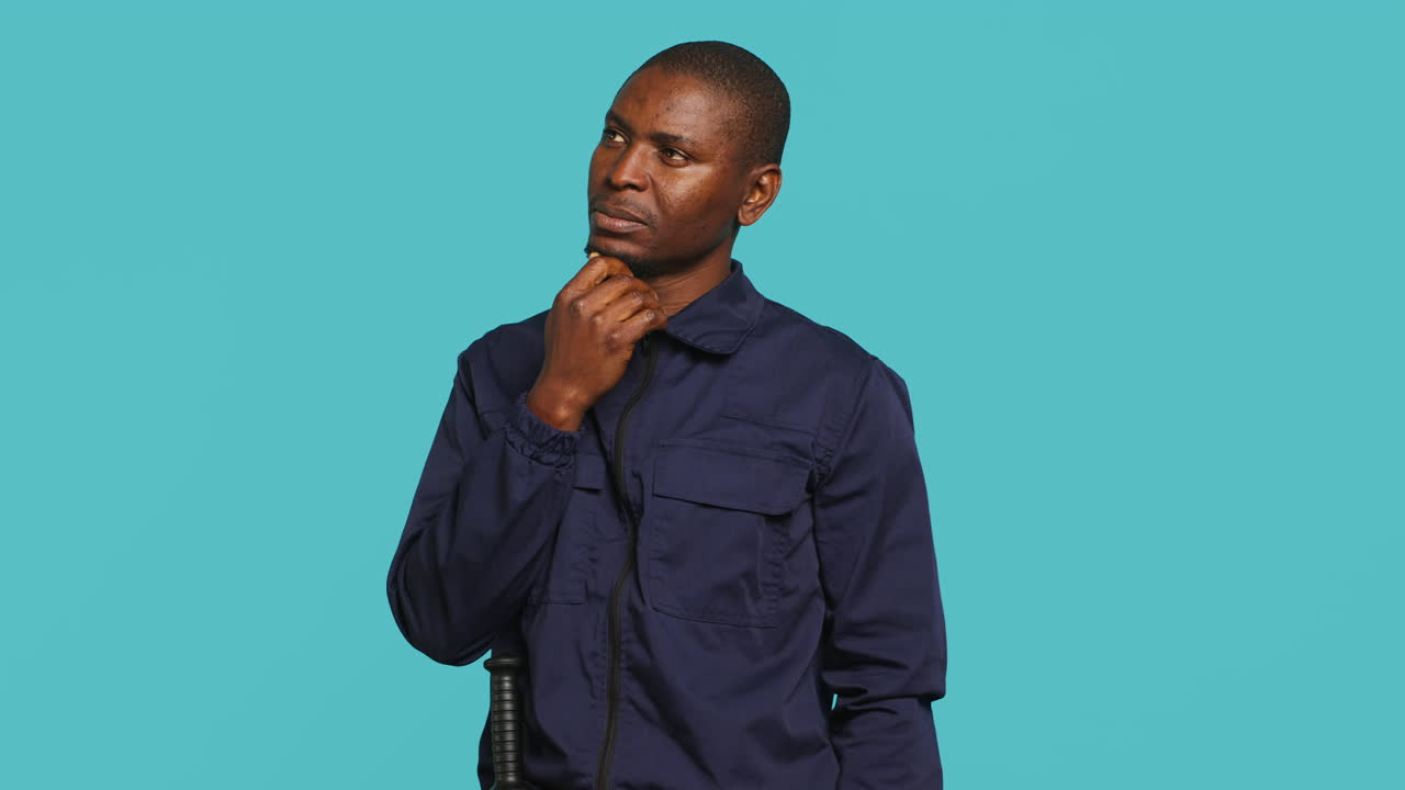 Portrait of pensive bodyguard rubbing chin, doing thinking hand gesture