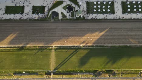 Carreras-De-Caballos-En-La-Pista-De-Carreras-Durante-La-Puesta-De-Sol,-Sobrecarga-Aérea