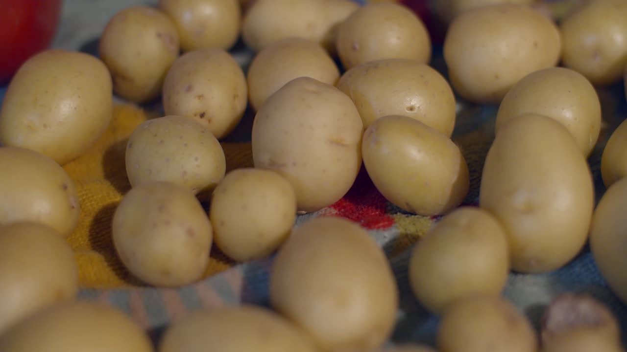 Close-up of many small potatoes on a cloth - Warm house vibes - cooking at home - 4k at 60fps (slowmotion)