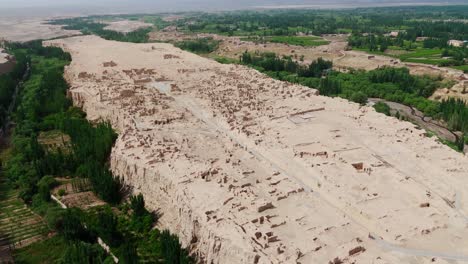 aerial establishing fly at natural archaeological ruins in chinese plateau, turpan jiaohe landscape
