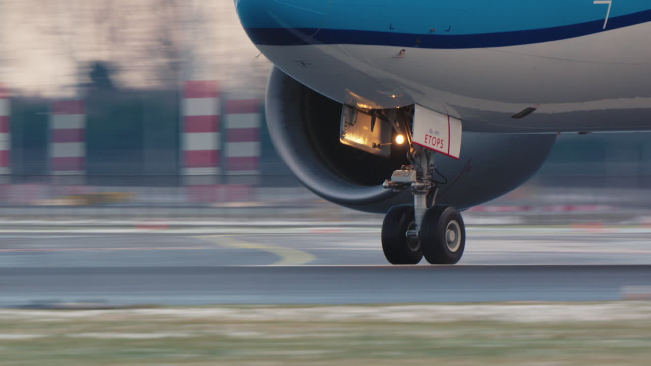 Primo piano del carrello d'atterraggio e del motore di un aereo commerciale sulla pista