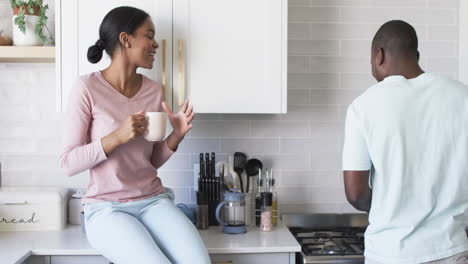 a diverse couple enjoys a conversation in a modern kitchen