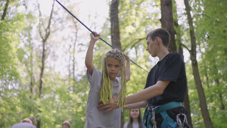 in the summer camp my daughter learns to overcome rope obstacles and rock climbing. teaching children about tourism and hiking