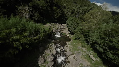 FPV-Antenne-Eines-Kleinen-Wasserfalls-Und-Baches-Durch-Den-Grünen-Wald-Der-Azoren