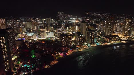 nighttime aerial view of waikiki with holiday lights and hotels on oahu hawaii night skyline and ocean wtih neighborhoods in back