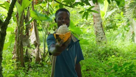 black young african male offering a cocoa looking and smiling straight to the camera