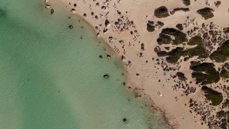 aerial - balos lagoon's main beach with sunbathers and turquoise waters, crete, greece