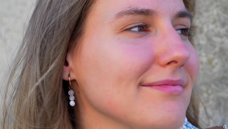 face of a blonde girl looking at camera and smiling calmly