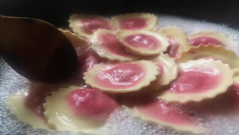 Stirring-colourful-Fiorelli-beetroot-and-goat-cheese-pasta-bubbling-in-hot-boiling-pan-of-water