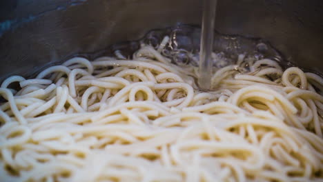 llenando una olla de fideos con agua en cámara lenta