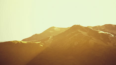 golden light illuminating rolling mountains at sunset in peaceful nature