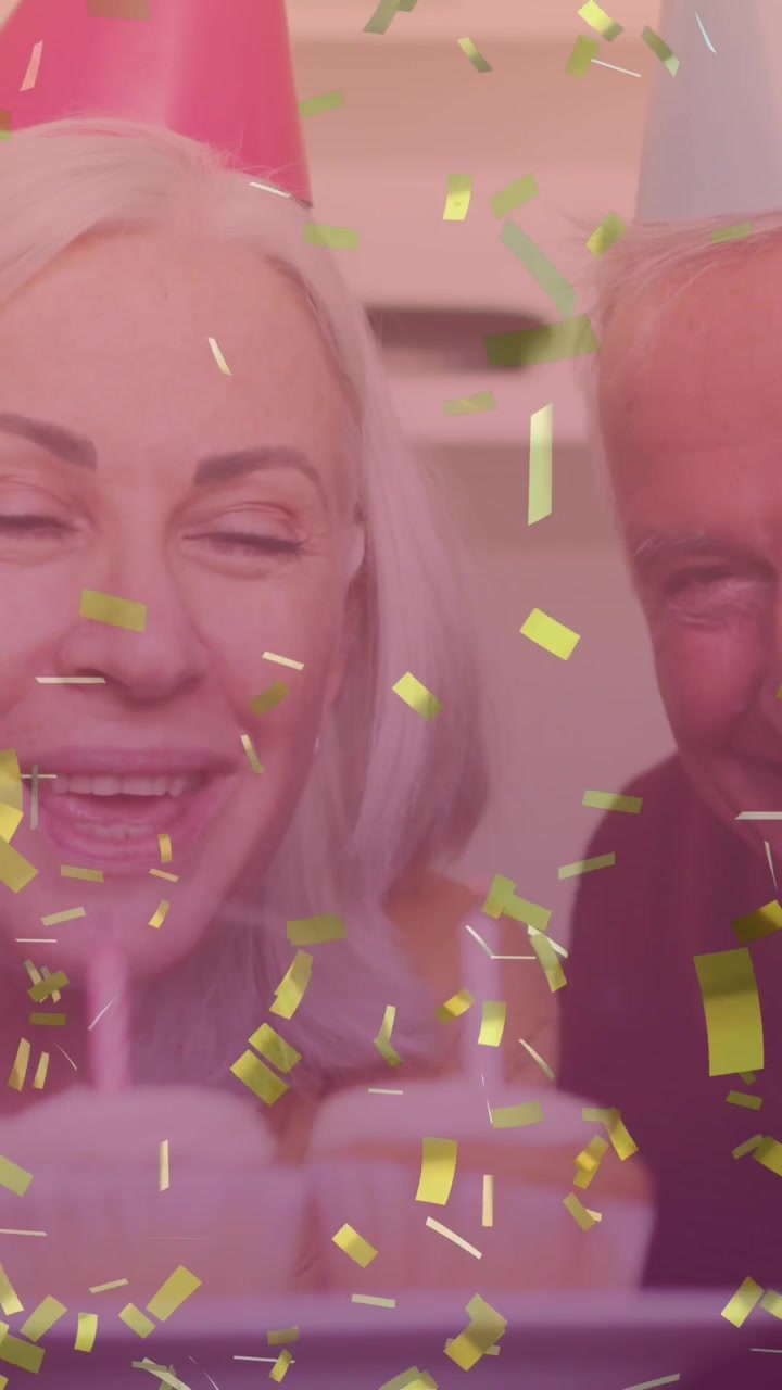 Video composito di coriandoli dorati che cadono su coppia anziana caucasica che festeggia il compleanno