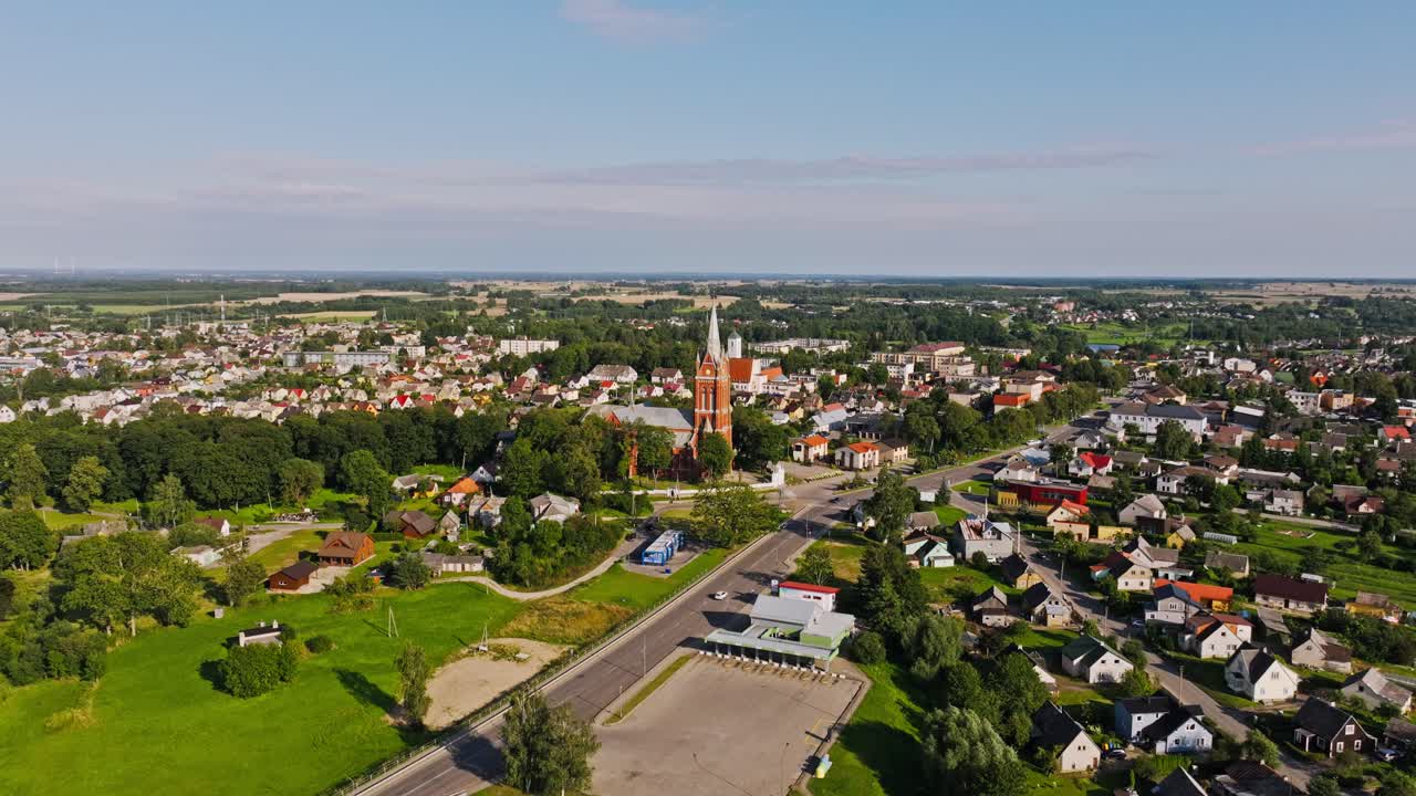 Cinematische openingsscène van een Litouws plattelandsstadje tijdens het gouden uur.