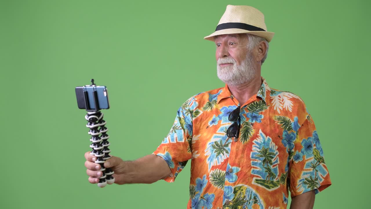 hombre turista barbudo y guapo listo para las vacaciones contra un fondo verde