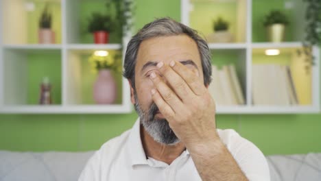 Close-up-mature-man-straightens-his-hair-and-beard-looking-at-the-camera.