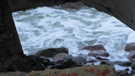 Grandes-Olas-Tormentosas-Rompiendo-Contra-Las-Ruinas-Abandonadas-Del-Edificio-De-Fortificación-Junto-Al-Mar-En-Los-Fuertes-Del-Norte-De-Karosta-En-Liepaja,-Cierre-Medio