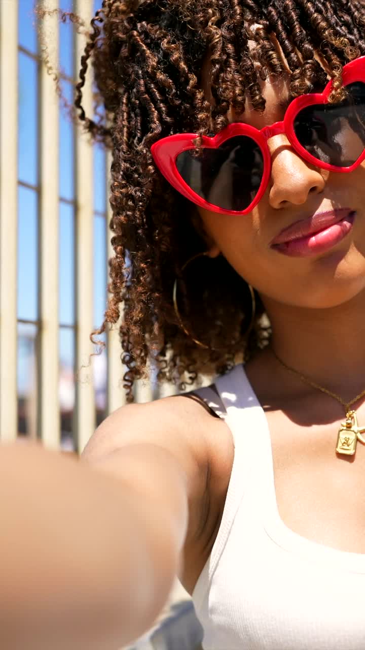 Người phụ nữ đeo kính râm hình trái tim màu đỏ đang chụp ảnh selfie