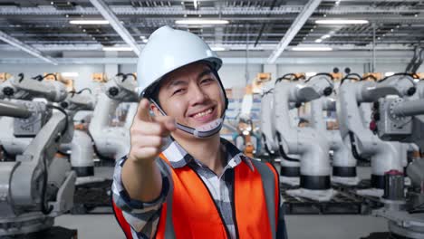 trabajador de la fábrica señalando a los robots