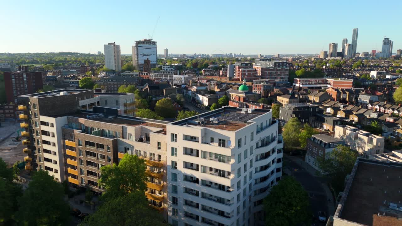 Modern apartment buildings and city skyline in summer sun over Acton, London