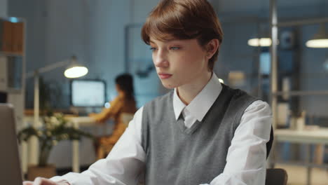 young businesswoman working on laptop late in office