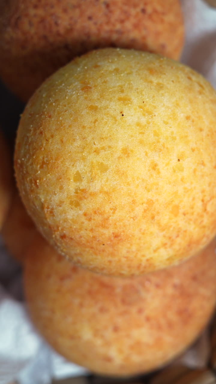 A close-up shot of golden almohabanas under warm lighting, showcasing their texture. Perfect for vertical video formats like social media stories. Vertical video