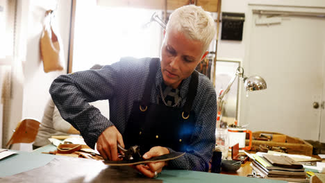 craftswoman punching hole from leather punch machine