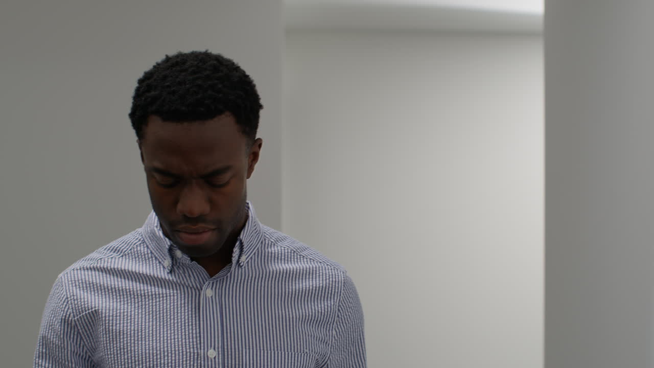 Young Businessman In Office Looking At Message With Bad News On Mobile Phone And Looks Unhappy And Depressed