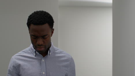 young businessman in office looking at message with bad news on mobile phone and looks unhappy and depressed