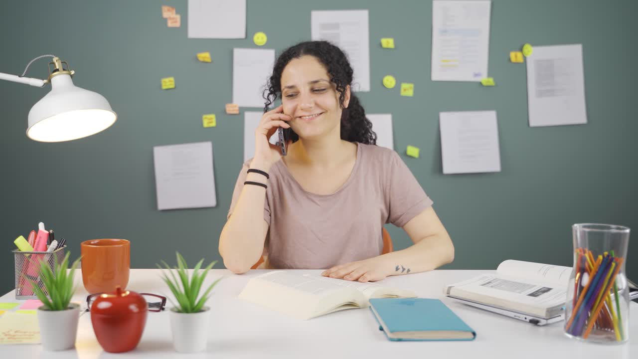 una estudiante recibe buenas noticias por teléfono.