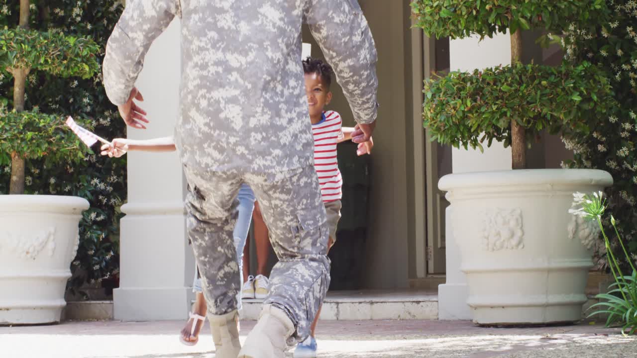 Soldato afroamericano che torna a casa, accolto dal figlio e dalla figlia felici, al rallentatore.